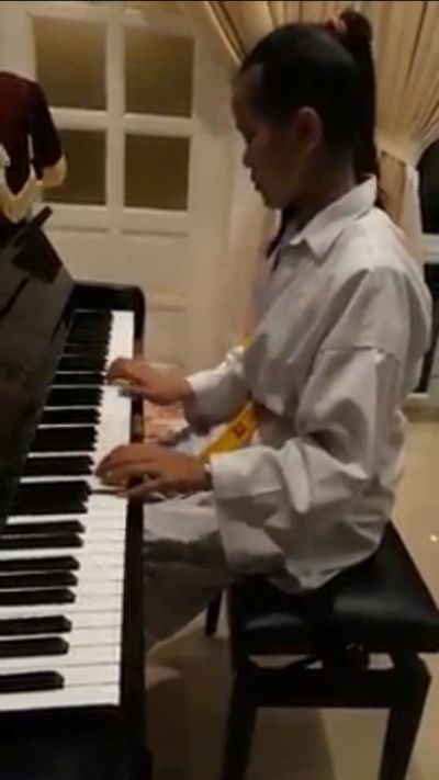 WEARING MARTIAL COSTUME AND PLAYING THE PIANO